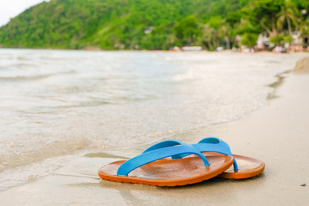 Beach sandals on the sandy sea, Summer concept with sandy beach. Vacation travel icon.の写真素材