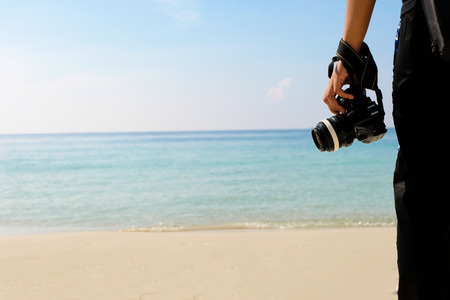 Photographer with camera Traveling backpacker of sea water and sand on the beach in tropical island with carefree and relaxing attitude - Travel Concept.の写真素材