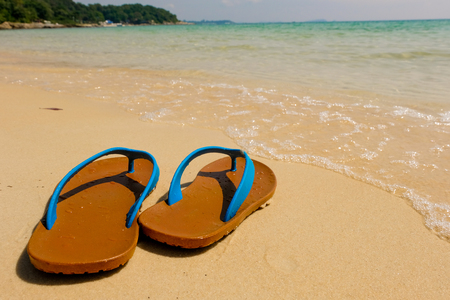 Beach sandals on the sandy sea, Summer concept with sandy beach. Vacation travel icon.の写真素材