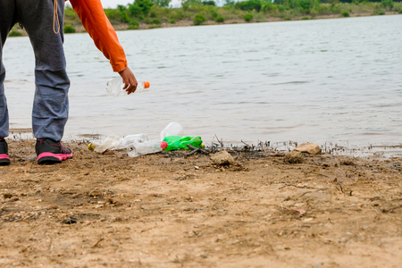 Young volunteers with garbage bags cleaning area in dirty beach of the lake, People and ecology. Volunteer concept.の写真素材