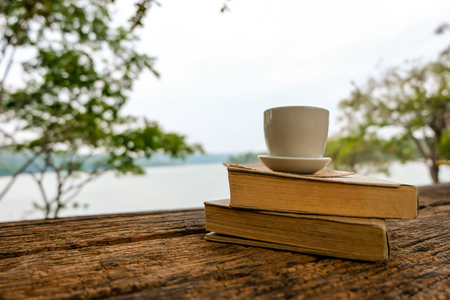 Relaxing moments, Book and coffee cup on the wood table. Relax time on holiday concept travel, Thailand. Color of Hipster Tone.の写真素材