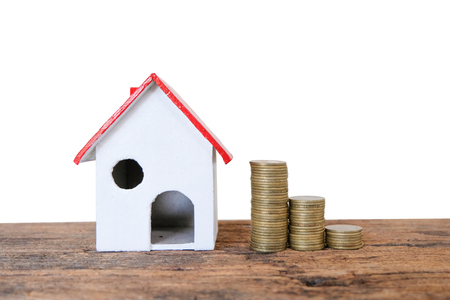 House Model and Coins Stacks on wooden table  isolated on white background. business, finance, concept of financial savings to buy a house.の写真素材