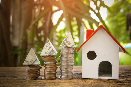 House Model and Coins Stacks on wooden table in the morning sunlight. business, finance, concept of financial savings to buy a house.の写真素材