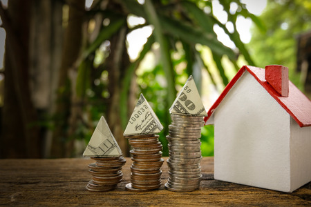 House Model and Coins Stacks on wooden table in the morning sunlight. business, finance, concept of financial savings to buy a house.の写真素材