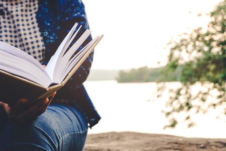 Relaxing moments, Young women opening and reading a book. Relax time on holiday concept travel, Thailand.の写真素材