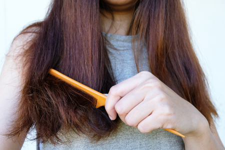 Sad Young Woman With Long Hair In Hand comb with brush ,Hair Damage, Health And Beauty Concept.の写真素材