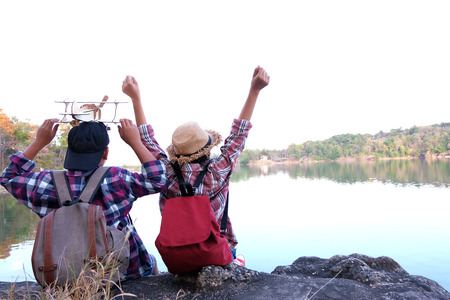 Two kids hiking with backpacks walking studying the route map in a sunny summer day on a forest, Relax time on holiday concept travel, Thailand.の写真素材
