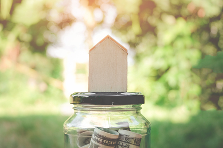 Model of house with Money growth coins Stacks on wooden table, Save and investment money for prepare in the future - Concept of finance investment.の写真素材