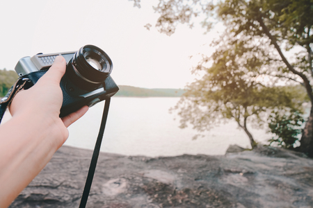 Traveler in nature with camera travel photo of photographer. Travel Lifestyle adventure concept vacations into the wild.の写真素材
