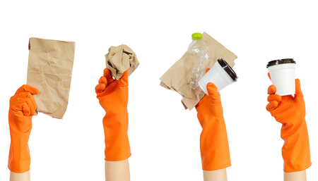 Hand of volunteer in yellow rubber gloves holding recyclable waste isolated on white background, use clipping path - volunteer concept.の写真素材