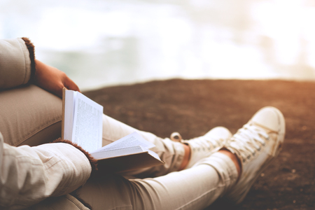 Relaxing moments, Young women opening and reading book enjoys of rest outdoor with summer vacations and lifestyle concept.の写真素材