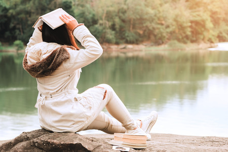 Relaxing moments, Young women opening and reading book enjoys of rest outdoor with summer vacations and lifestyle concept.の写真素材