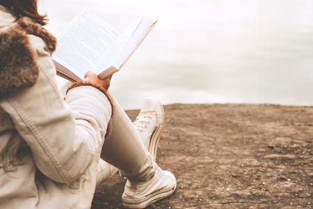 Relaxing moments, Young women opening and reading book enjoys of rest outdoor with summer vacations and lifestyle concept.の写真素材
