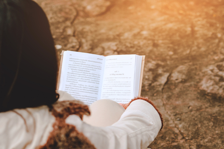 Relaxing moments, Young women opening and reading book enjoys of rest outdoor with summer vacations and lifestyle concept.の写真素材