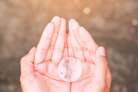 Glass globe in human hand - Environment care symbol, global protection conceptの写真素材