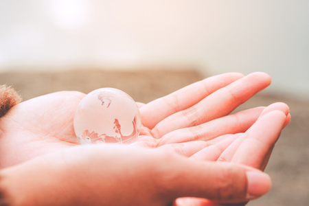 Glass globe in human hand - Environment care symbol, global protection conceptの写真素材
