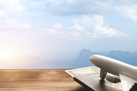 Mountain landscape with a view of the forest and white model of passenger plane on old wooden background. Travel saving and planning conceptの写真素材