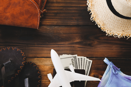 Top view essential travel items passport, airplane, Hat, money, Sandals, shells on old wooden background. tourism and trip vintage. planning summer holiday, Travel conceptの写真素材