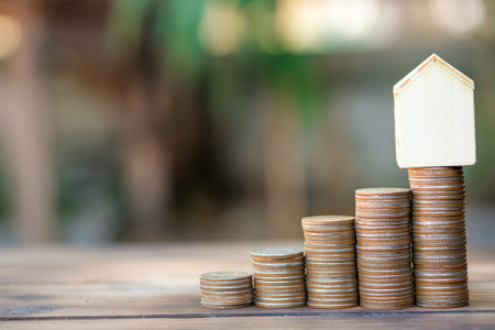 Model house, Money growth in soil . While seedlings are growing on pile of coins - Concept finance investment.の写真素材