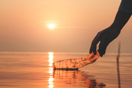 Hand Woman picking up empty of plastic bottle cleaning on the beach , volunteer concept. Environmental pollution. Ecological problem.の写真素材