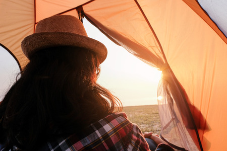 Feet of young women relaxing with lake view from tent camping entrance outdoor. Travel wanderlust lifestyle concept adventure vacations outdoor, Summer holiday and vacation tripの写真素材