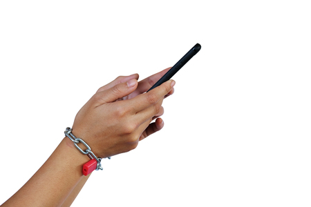 Hands and smartphone tied with metallic chain with padlock isolated on white background with clipping path. Social Disease - mobile phone addiction concept.の写真素材