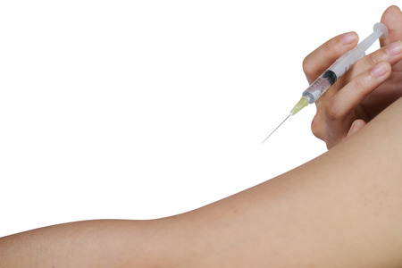 Disposable syringe with the drug in female hand injecting himself in the arm, Inoculation - isolated on white background with clipping path.の写真素材