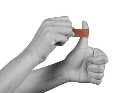 Hand women with adhesive plaster that covering a slight injury - isolated on white background with clipping path.の写真素材