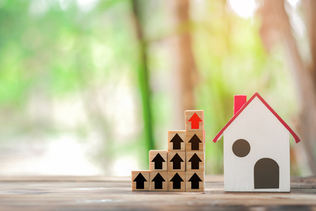 Wood block stacking as step stair and model house, business growth to success. Startup concepts with business strategy symbols on wooden cubes - business success concept.の写真素材