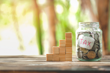 saving money with hand putting coins in jar glass, save and investment money for prepare in the future - saving financial conceptの写真素材