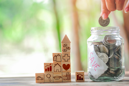 Wood block stacking as step stair and coins in jar glass, business growth to success.Startup concepts with business strategy symbols on wooden cubes - Risk management.の写真素材