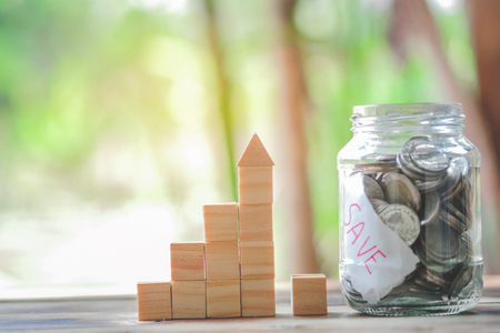 Wood block stacking as step stair and coins in jar glass, business growth to success.Startup concepts with business strategy symbols on wooden cubes - Risk management.の写真素材