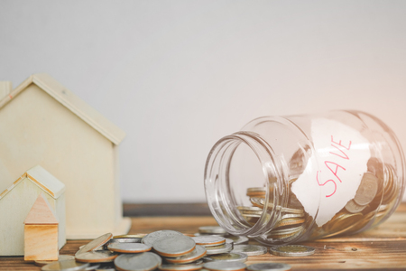 saving money with hand putting coins in jar glass, save and investment money for prepare in the future - saving financial conceptの写真素材