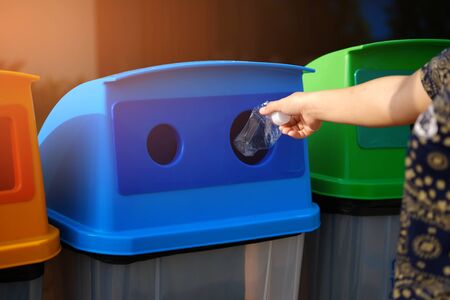 Young volunteers throw waste into the bucket, cleaning area in park, People and ecology. Volunteer concept.の写真素材