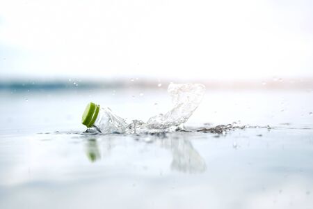 Plastic water bottles pollution in ocean, cleaning on the beach, volunteer concept. Environmental pollution. Ecological problem.の写真素材