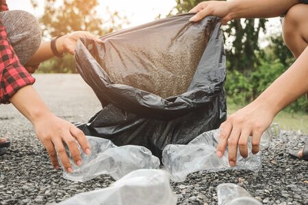 Young volunteers with garbage bags cleaning area in park, People and ecology. Volunteer concept.の写真素材