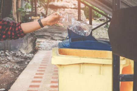 The volunteer picking put a bottle plastic into the tank for cleaning, volunteering concept. Environmental pollution and Ecological problem.の写真素材