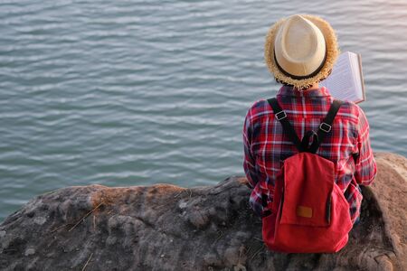 Pretty relaxed young woman reading a book in quiet nature, concept read a books.の写真素材
