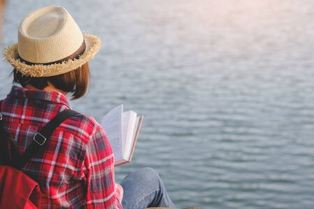 Pretty relaxed young woman reading a book in quiet nature, concept read a books.の写真素材