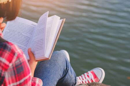 Pretty relaxed young woman reading a book in quiet nature, concept read a books.の写真素材