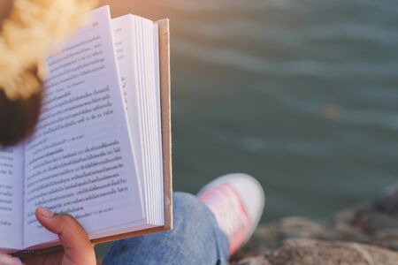 Pretty relaxed young woman reading a book in quiet nature, concept read a books.の写真素材