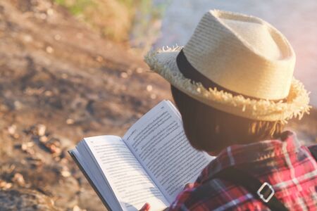 Pretty relaxed young woman reading a book in quiet nature, concept read a books.の写真素材