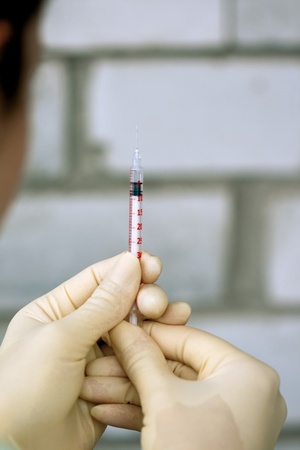 A syringe in human handsの写真素材