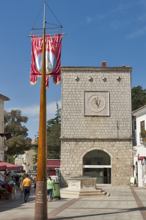 KRK, CROATIA - AUGUST 11: Town Council Hall and flag with coat of arms on Vela Market Place on August 11, 2012 in Krk, Croatia. Krk town is located on the southwest coast of the island Krk and have about 3000 years of history. Vela Market Place was first のeditorial素材