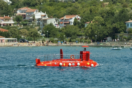 KRK, CROATIA - AUGUST 11: Entertainment submarine sailing along the beach with resting people on August 11, 2012 in Krk, Croatia. Krk town is a summer resort located on the southwest coast of the island Krk and have about 3000 years of history.のeditorial素材