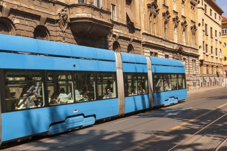 ZAGREB, CROATIA - AUGUST 21: Pedestrians walk along city street with old houses and passengers travel by tram in Zagreb, Croatia on August 21, 2012.のeditorial素材