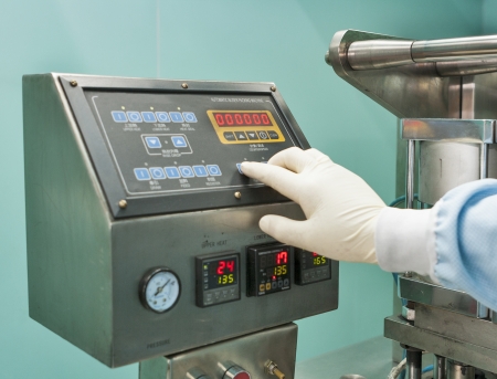 bliser packing machine remote control and human hand in gloves