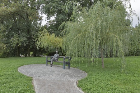 LJUBLJANA, SLOVENIA - SEPTEMBER 04, 2015: Slovenian poet Oton Zupancic statue in Tivoli park. There is also a little version of him on the arm of the bench, representing the puppet work of Zupancic.のeditorial素材