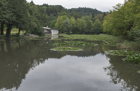LJUBLJANA, SLOVENIA - SEPTEMBER 04, 2015: Tivoli Pond and restaurant with unrecognizable people in early autumn. View towards the north, with Roznik Hill in the background. Tivoli Park is the capital's largest park.のeditorial素材