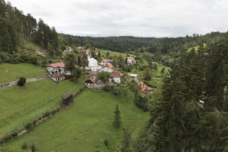 View out the window of the Predjama Castle on village and Church of Our Lady of Sorrows, Sloveniaの写真素材